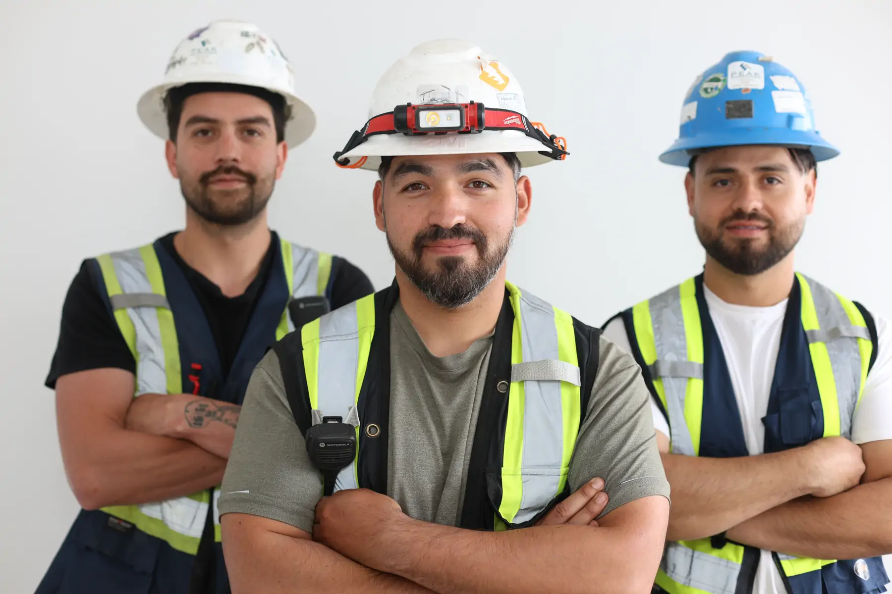 JF West Coast foreman with two crew members in hard hats and hi-vis vests