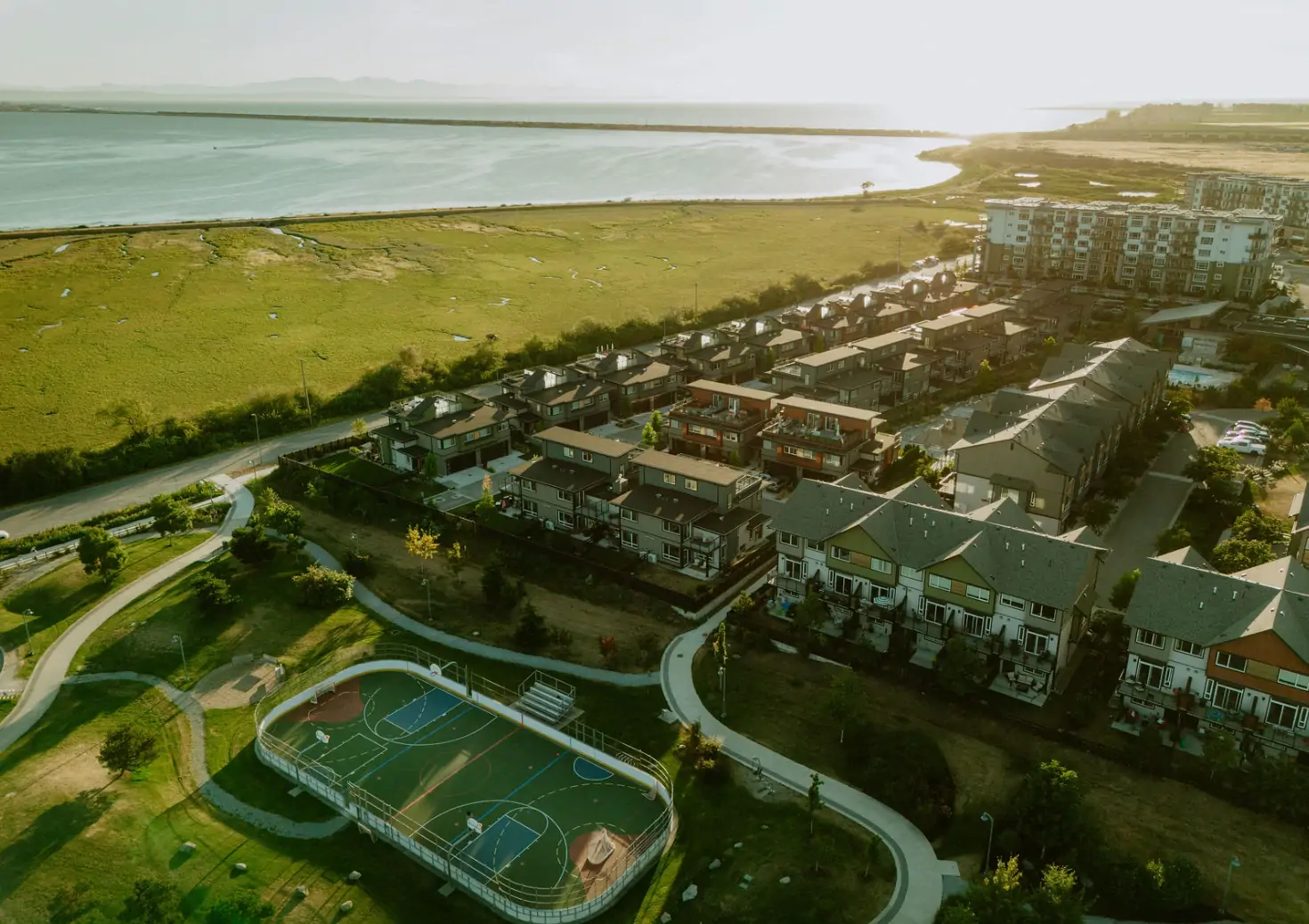 Aerial view of the Boardwalk homes in Tsawwassen beside the waterfront marsh and sports court